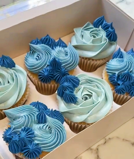 Luxury handcrafted cupcakes with swirls of vanilla buttercream and elegant edible decorations